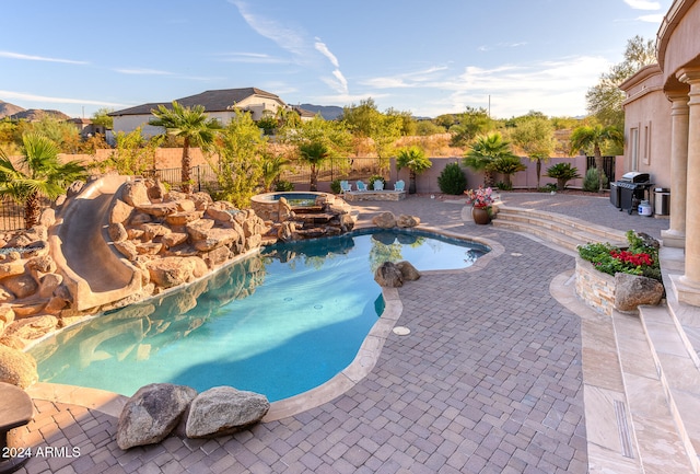 view of pool with an in ground hot tub, area for grilling, and a patio area