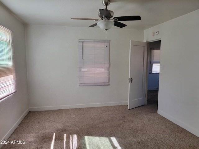 carpeted spare room with ceiling fan