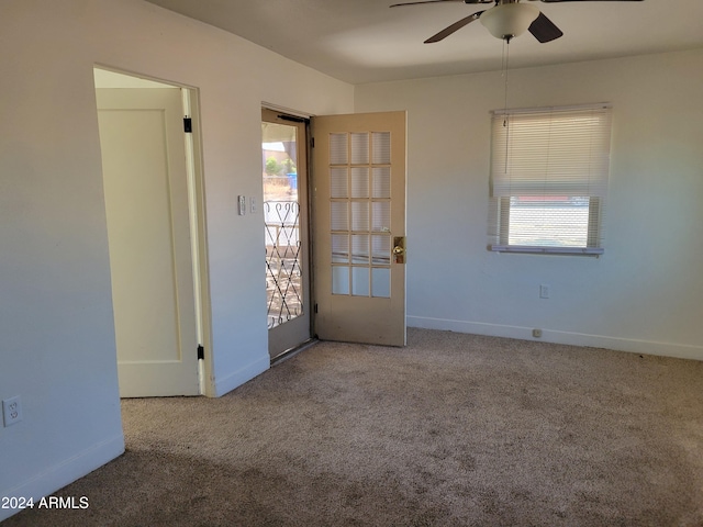 carpeted spare room featuring ceiling fan