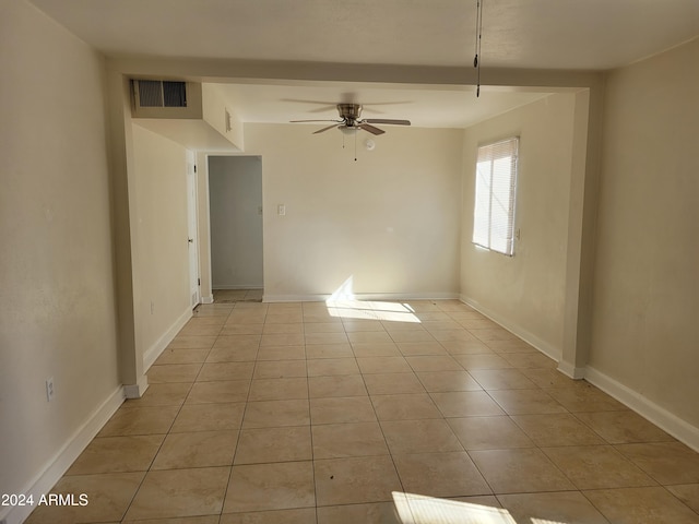 tiled empty room featuring ceiling fan