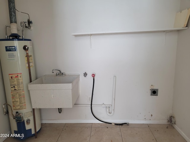 washroom with hookup for a washing machine, light tile patterned floors, water heater, sink, and electric dryer hookup