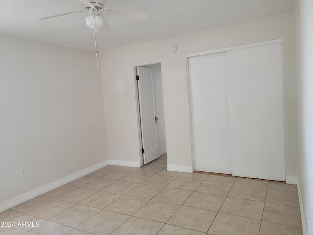 unfurnished bedroom featuring light tile patterned floors, ceiling fan, and a closet