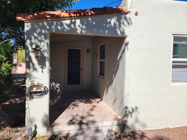 view of exterior entry with a patio