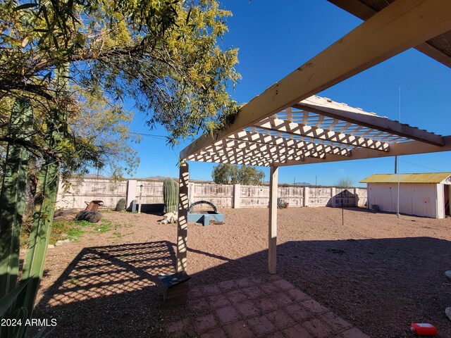 view of yard with a pergola and a storage unit