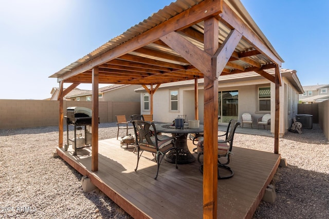 12505 W Kaler Dr, Glendale, AZ 85307 - wooden deck with a fenced backyard, a grill, outdoor dining space, and central AC unit