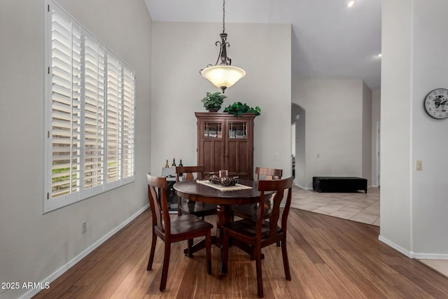 23813 S Pleasant Way, Sun Lakes, AZ 85248 - dining room with arched walkways, baseboards, wood finished floors, and a high ceiling