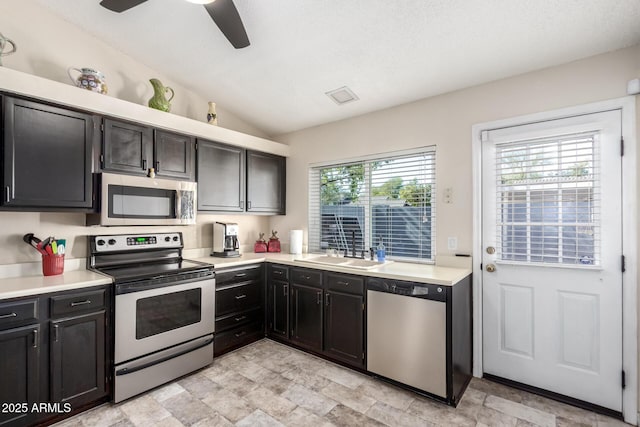 kitchen with lofted ceiling, sink, stainless steel appliances, and ceiling fan