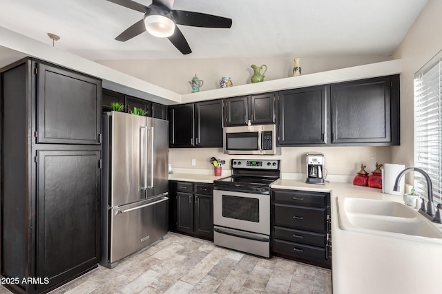 kitchen with lofted ceiling, sink, ceiling fan, and appliances with stainless steel finishes