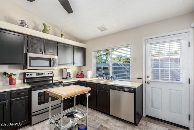 kitchen featuring sink, vaulted ceiling, ceiling fan, and appliances with stainless steel finishes