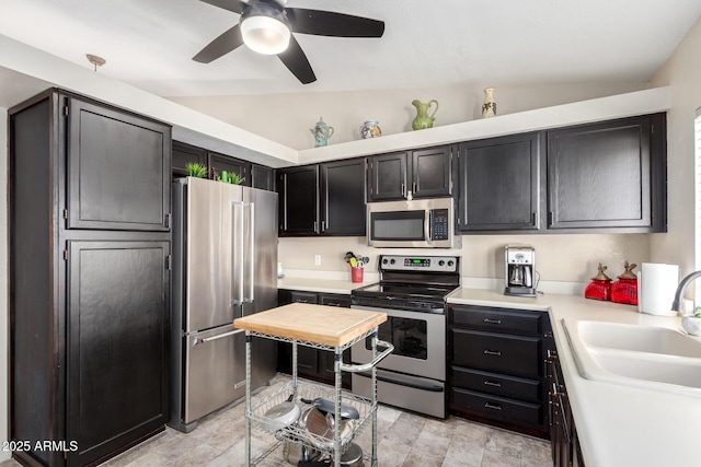 kitchen featuring vaulted ceiling, appliances with stainless steel finishes, sink, and ceiling fan