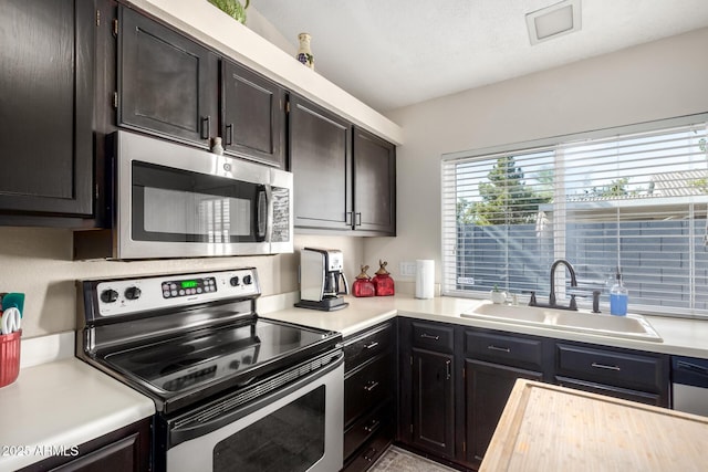 kitchen featuring dark brown cabinetry, stainless steel appliances, and sink