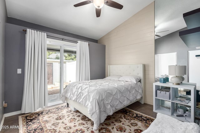 bedroom with lofted ceiling, dark tile patterned floors, ceiling fan, access to exterior, and wooden walls