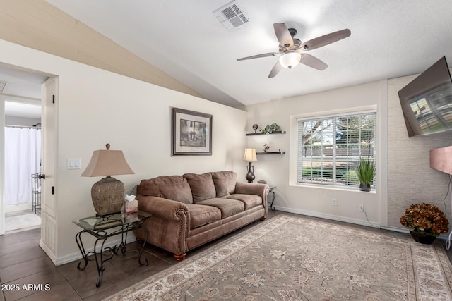 tiled living room with ceiling fan and vaulted ceiling