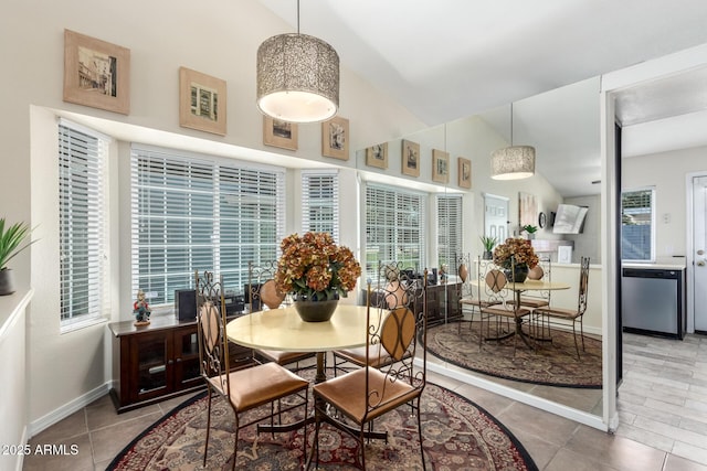 dining space featuring tile patterned flooring and vaulted ceiling