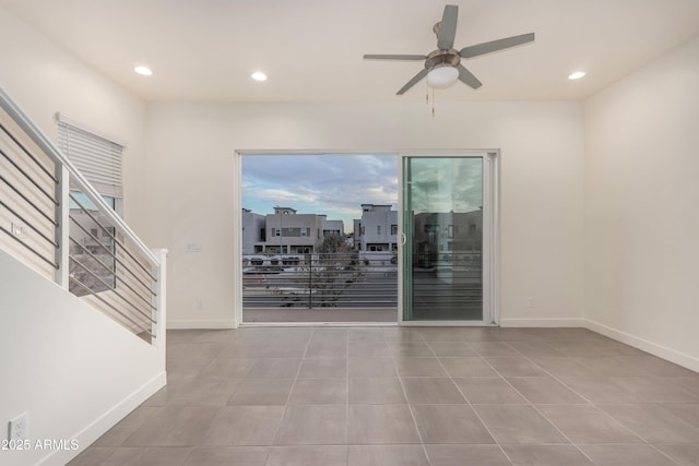 tiled spare room featuring ceiling fan