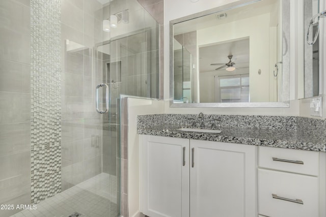 bathroom featuring ceiling fan, vanity, and walk in shower