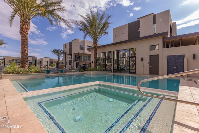 view of swimming pool with a hot tub