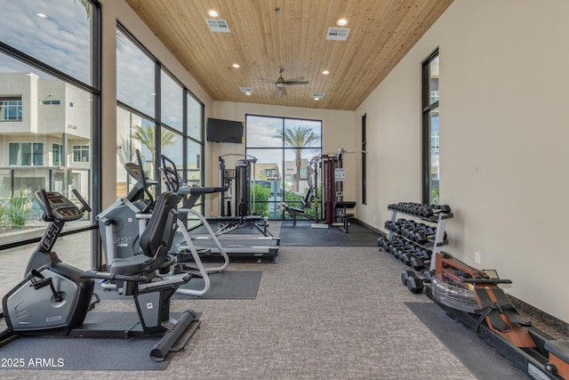 exercise room featuring a high ceiling, ceiling fan, and wood ceiling