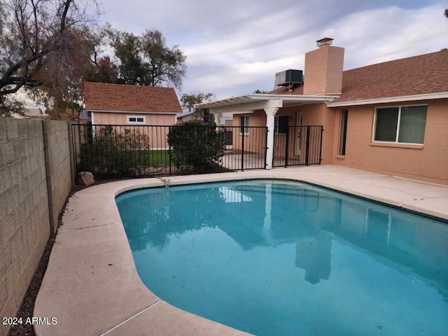 view of pool with central AC unit and a patio