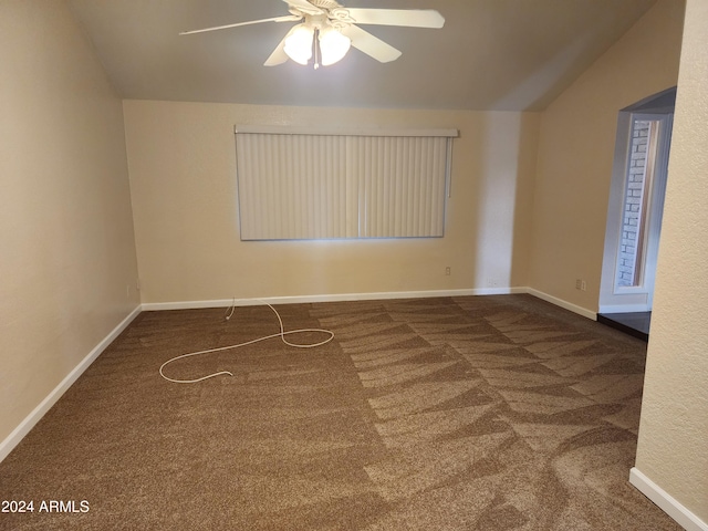 spare room featuring ceiling fan, lofted ceiling, and dark colored carpet