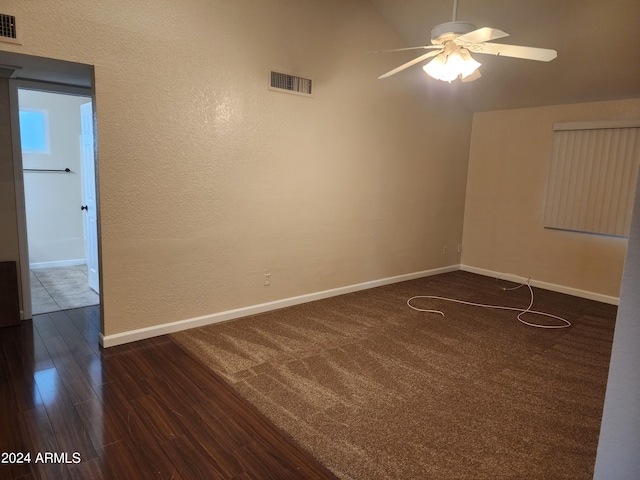 unfurnished room with dark colored carpet and ceiling fan