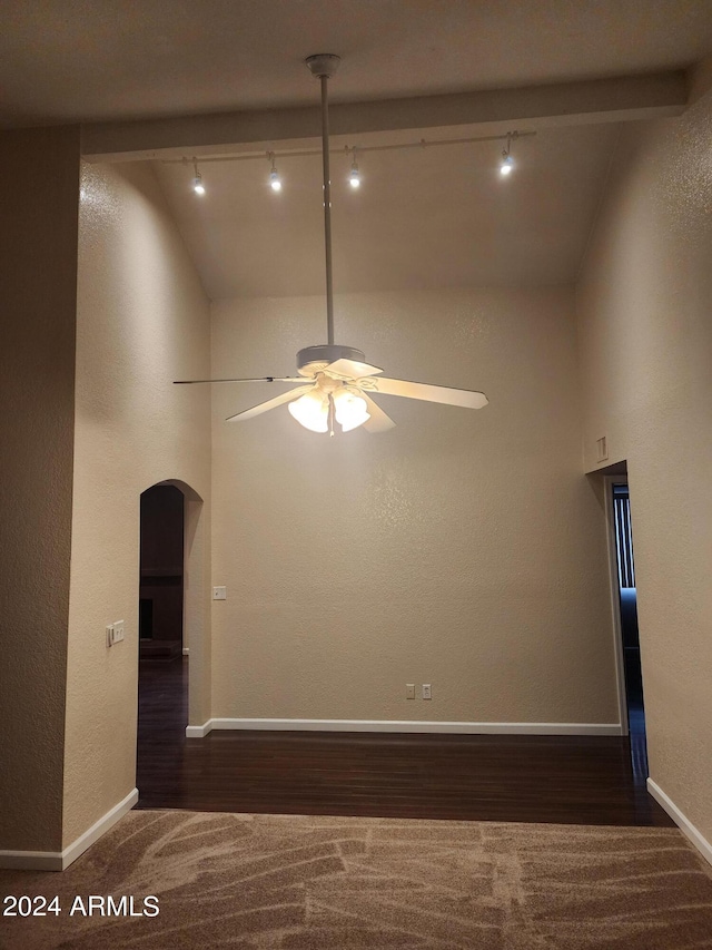 unfurnished room featuring beamed ceiling, high vaulted ceiling, dark colored carpet, track lighting, and ceiling fan