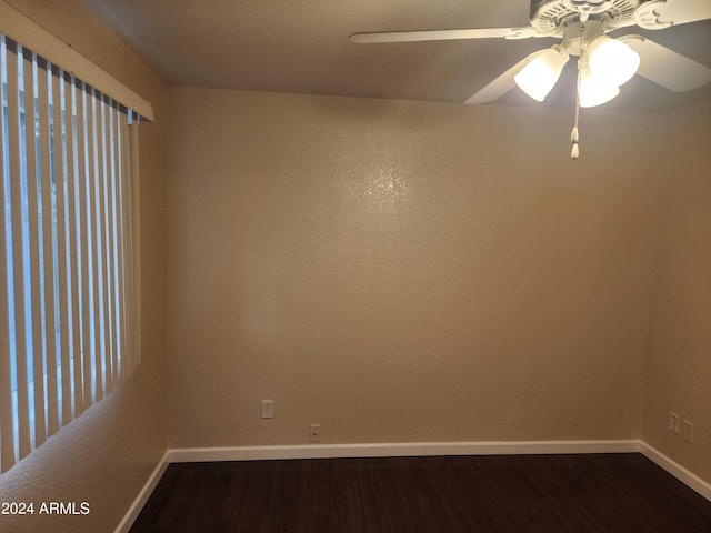 spare room with dark hardwood / wood-style flooring and ceiling fan