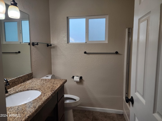 bathroom with toilet, vanity, and tile flooring