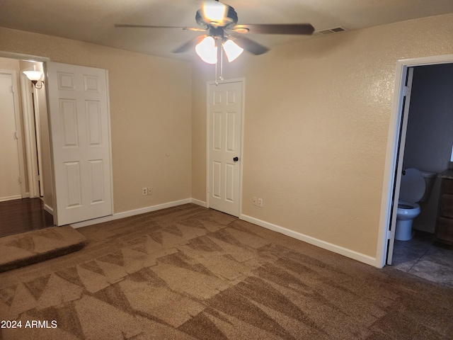 unfurnished room with ceiling fan and dark colored carpet