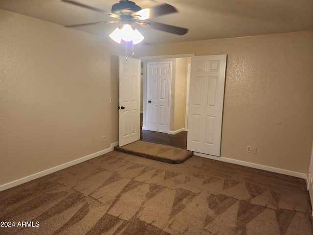 unfurnished room featuring dark carpet and ceiling fan