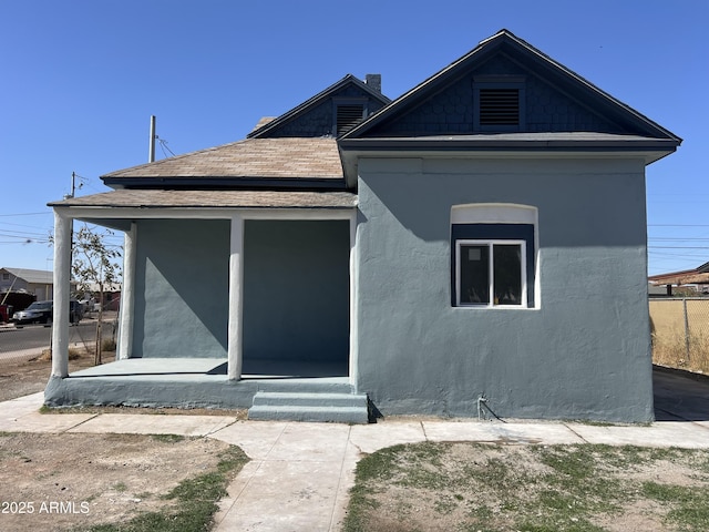 view of front of house with a shingled roof and stucco siding