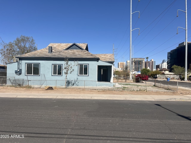 bungalow-style house featuring a fenced front yard and stucco siding