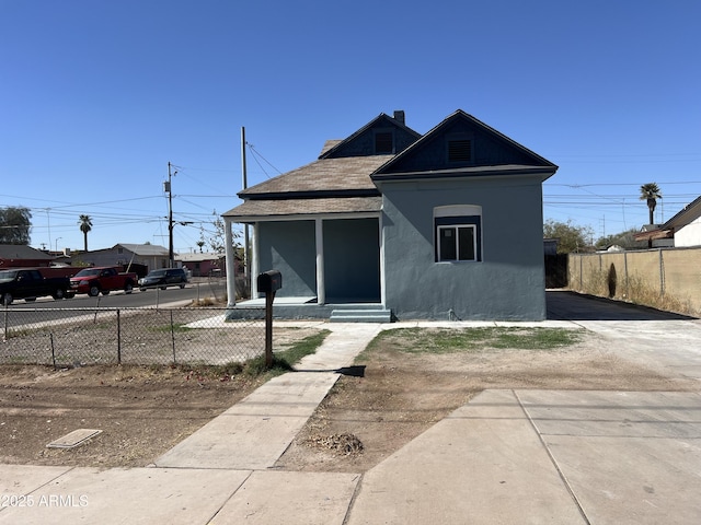 bungalow-style home with a fenced front yard and stucco siding