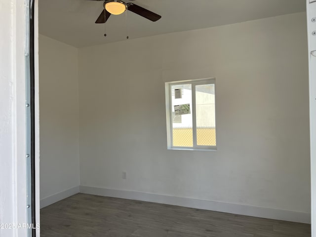 empty room featuring ceiling fan, baseboards, and wood finished floors