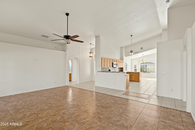 unfurnished living room featuring visible vents, arched walkways, a ceiling fan, and light tile patterned flooring