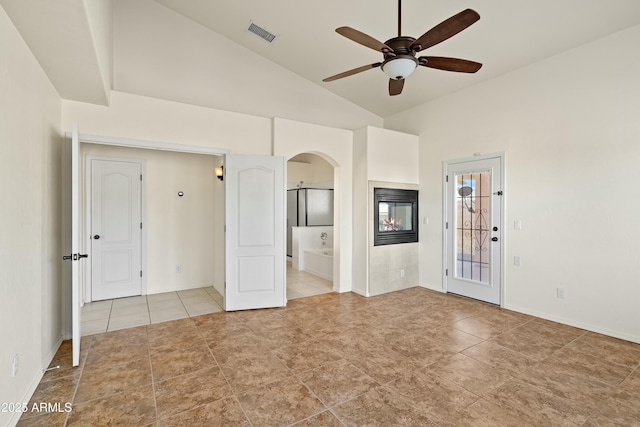 unfurnished room with arched walkways, visible vents, a ceiling fan, high vaulted ceiling, and a multi sided fireplace