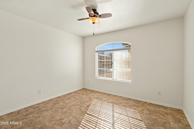 spare room featuring ceiling fan and baseboards