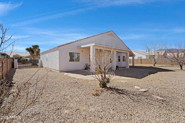 rear view of property with a patio area, a fenced backyard, and stucco siding