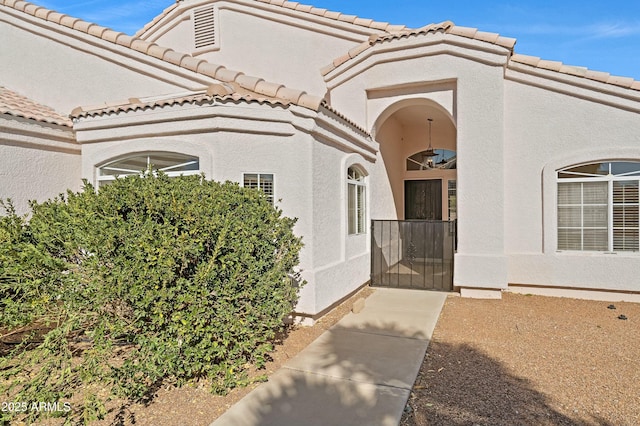 entrance to property with a tiled roof and stucco siding