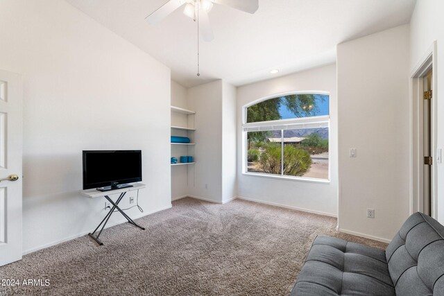 carpeted living room with ceiling fan