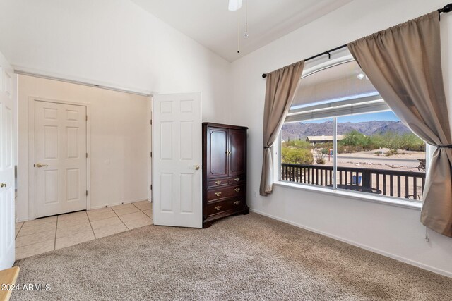 unfurnished bedroom featuring a mountain view, high vaulted ceiling, and light colored carpet