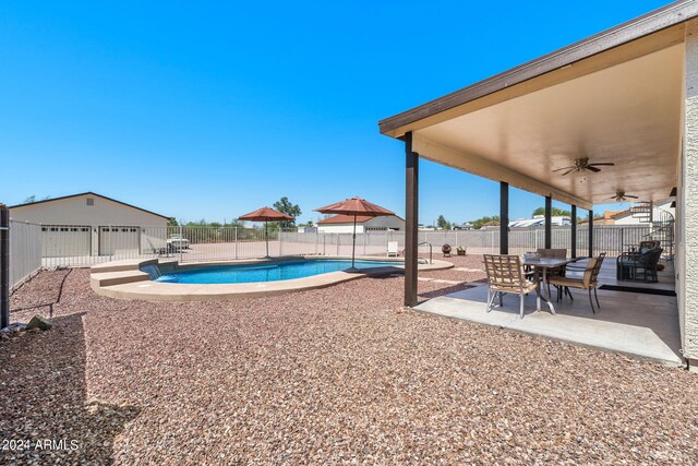 view of swimming pool with ceiling fan, a shed, and a patio