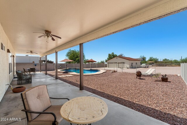 view of patio / terrace with ceiling fan and a fenced in pool