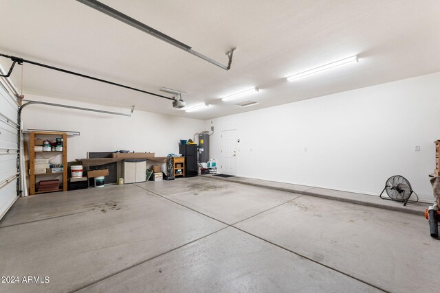 garage with water heater and a garage door opener