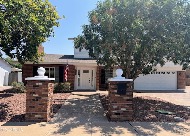 view of front of property with a garage, brick siding, and driveway