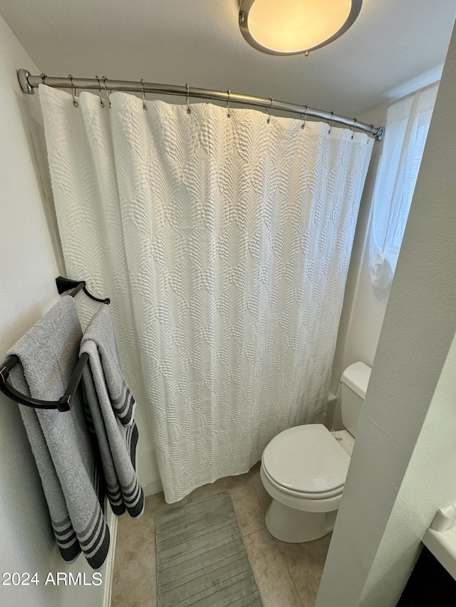 bathroom with toilet and tile patterned floors