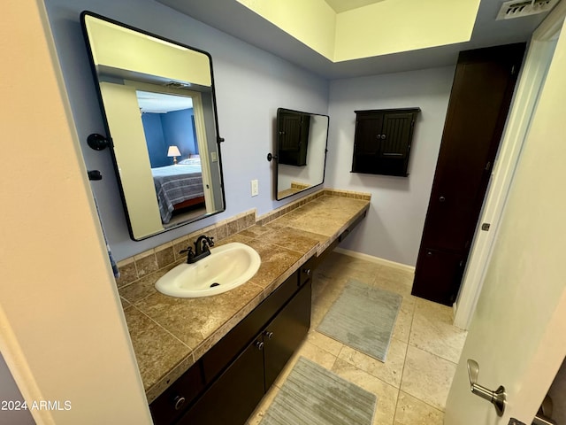 ensuite bathroom with ensuite bath, vanity, visible vents, and baseboards