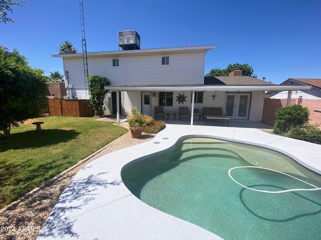 back of property with french doors, a lawn, a patio area, fence, and cooling unit