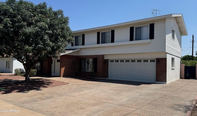 traditional-style home featuring brick siding, driveway, and an attached garage