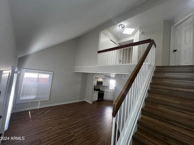 stairway featuring wood-type flooring and lofted ceiling